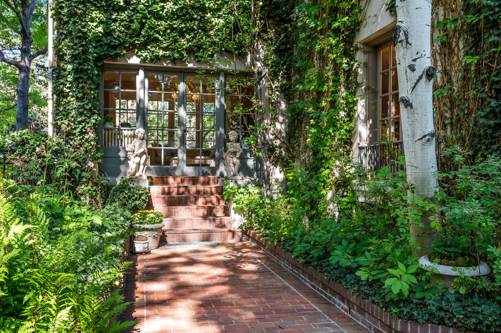 Brick walkway and ivy-covered French doors