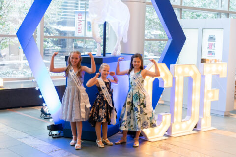 Three little girls posed to show they are strong.
