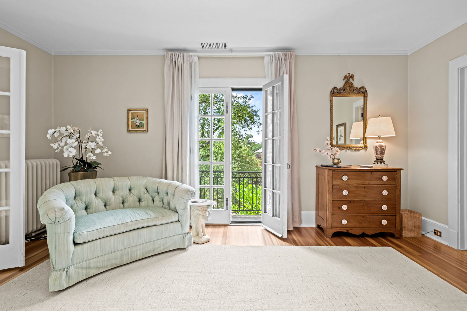Mint green couch beside an open French door