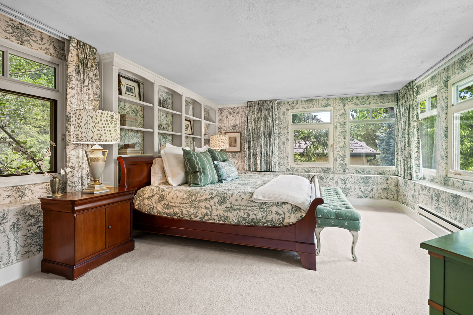 Bedroom with green bedding, curtains, and wallpaper