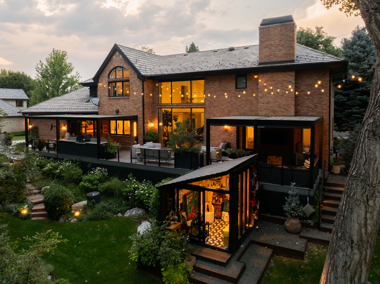 All glass studio behind a two-story brick home