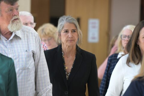 Missy Woods, in a black blazer, walks through court hallway