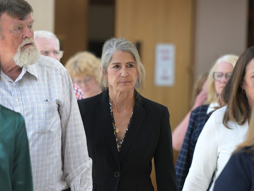 Missy Woods, in a black blazer, walks through court hallway