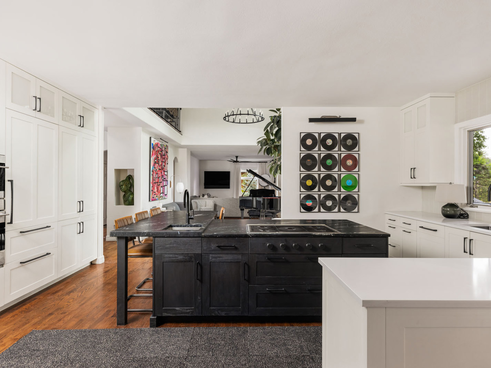 White kitchen with vinyls on the wall and a black kitchen island