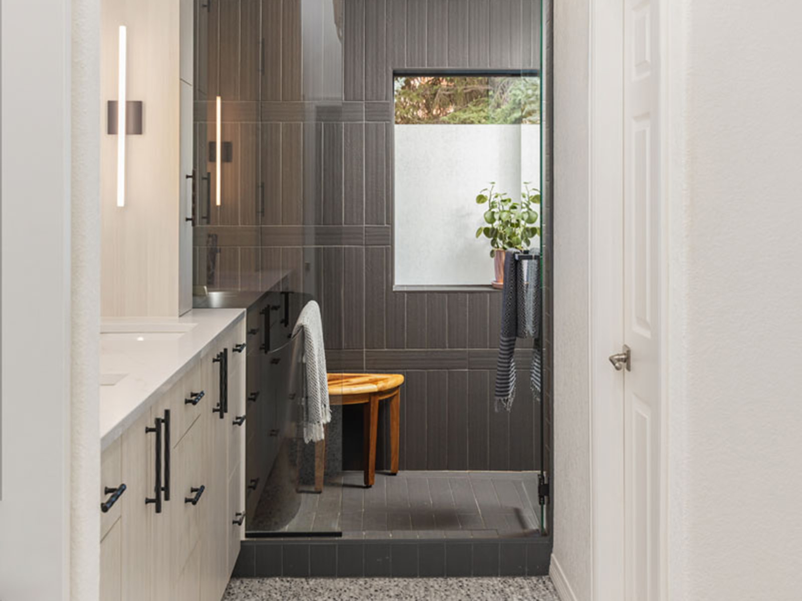 White bathroom with a black tile wet room in the back