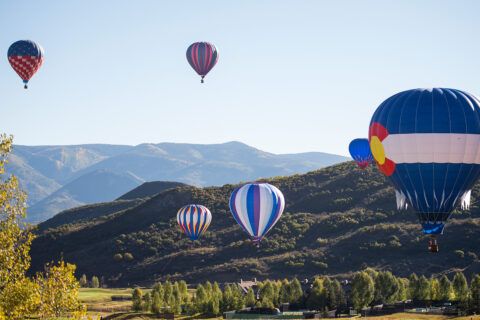 Hot air balloons hover over Snowmass village