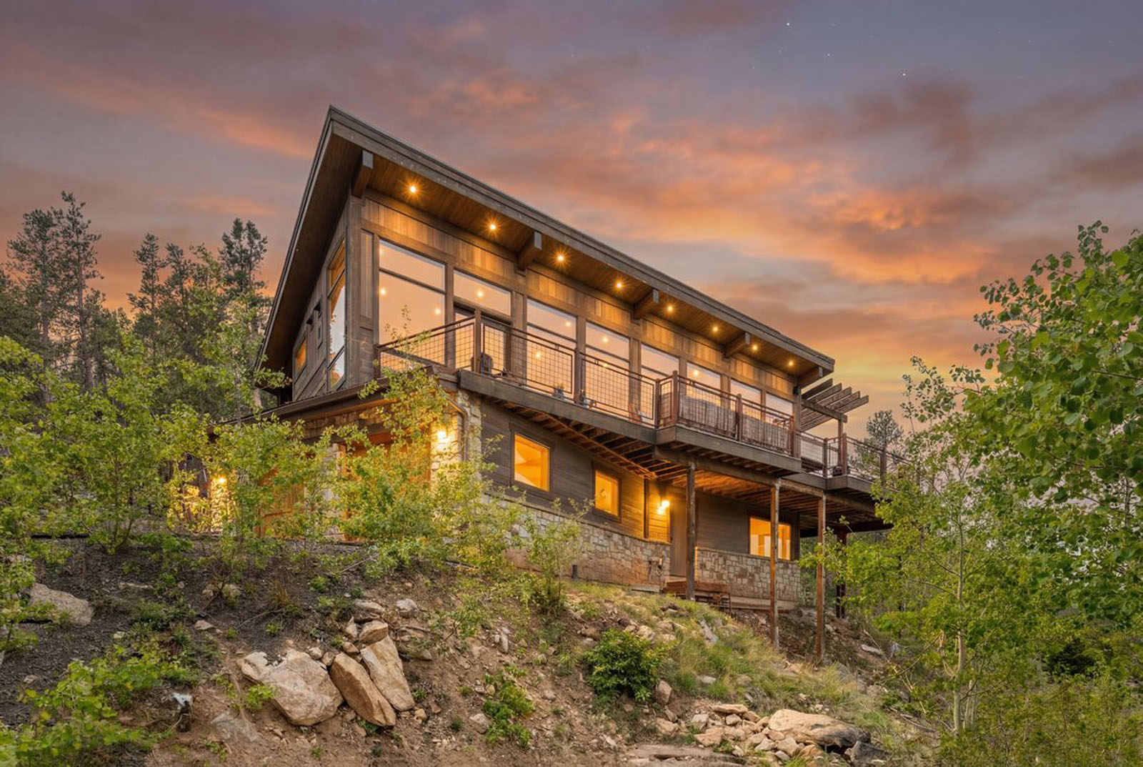 Facade of two-story mountain house at dusk