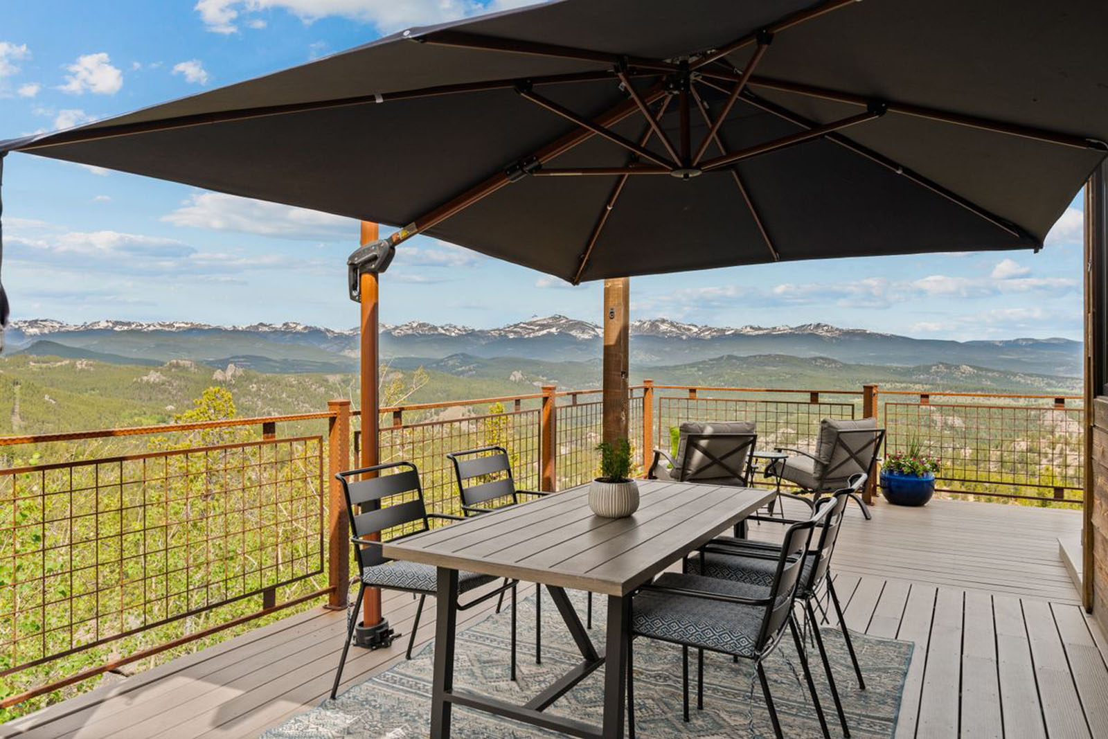 Outdoor dining table and chairs on a deck overlooking the Indian Peaks
