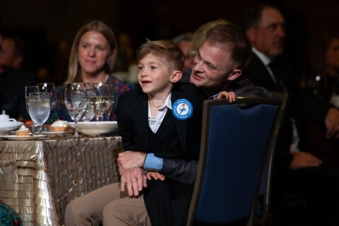 A man holding a child at a dinner table.
