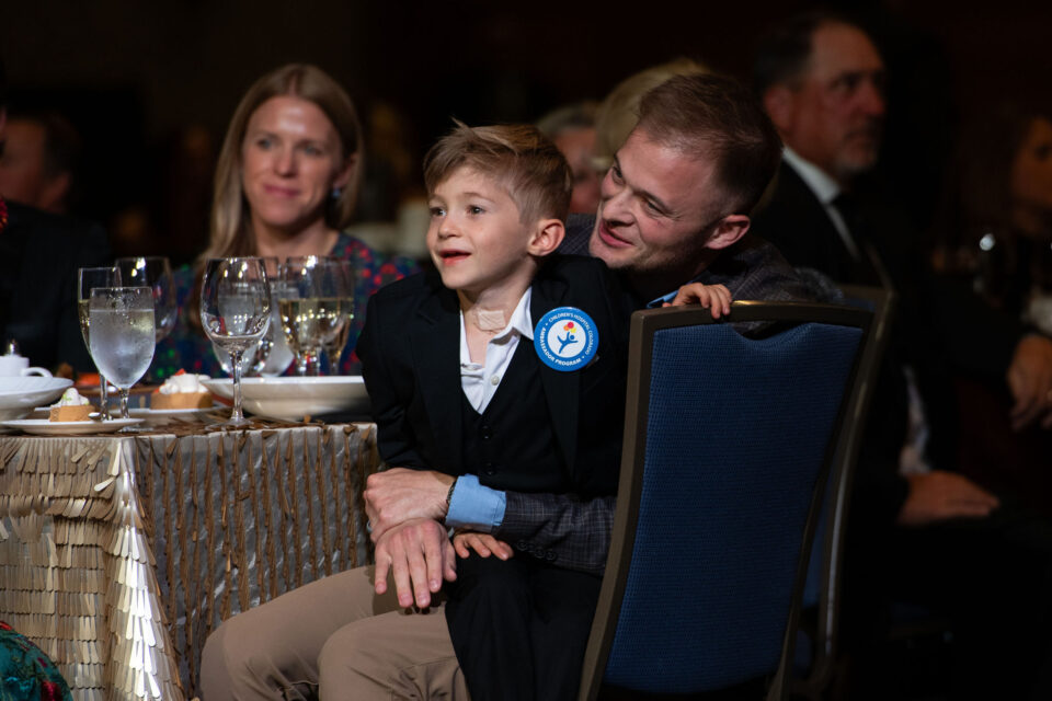 A man holding a child at a dinner table.