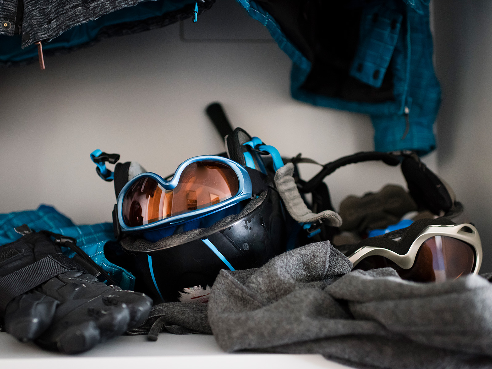 Ski gear cluttered at the bottom of a closet